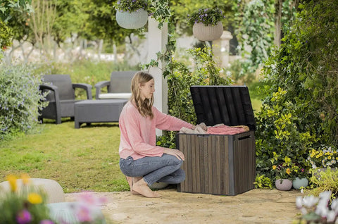 Woman using Backyard Must-Have Everwood 30 Gallon Resin Outdoor Storage Box And Patio Side Table For Pool And Garden Accessories Walnut Finish