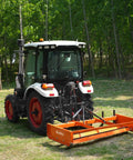Black tractor with Heavy Duty 72 Inch Tractor Land Leveler Scraper Grader Attachment on grass field, rear view
