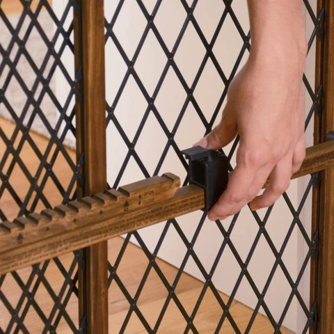 Hand operating latch on Position And Lock Adjustable Wood Baby Gate For Farmhouse Style Homes, Fits 26 To 42 Inch Openings, 23 Inch Tall