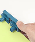 Hand holding AU93 Edge Banding Trimmer With Dual Edge Cutting And Scraper trimming a yellow edge on wood laminate.
