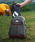 Hand placing folded Ultralight Aluminum Camping Side Table With Carry Bag into backpack on grass near yellow tent