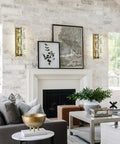 Lit Crystal Glass Wall Sconce In Gold Finish lighting a living room, showcasing Mid Century Modern style with brick walls.