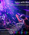DJ using UV Black Light Lit Glow Party Kit 3 Pack with remote sound activated LED disco ball lights, vibrant purple glow at party.