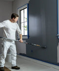 Painter using ProGrade Painter Tape With PaintBlock Technology Blue 1.5 Inch Wide Multi Surface Masking Tape for sharp lines on wall.