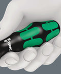 Hand holding a black and green handle of an actuation tool for terminal blocks with spring cages