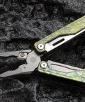 Ultra Lightweight Titanium Alloy Multitool Pliers With Camouflage Finish, 420 Stainless Steel Plier Head on rugged surface