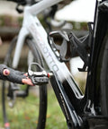 Cyclist installing Assioma PRO RS-2 Dual Sensing Pedal Based SPD SL Road Power Meter on a road bike