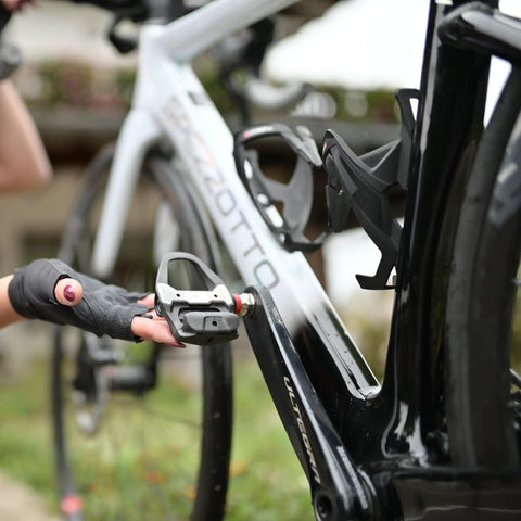 Cyclist installing Assioma PRO RS-2 Dual Sensing Pedal Based SPD SL Road Power Meter on a road bike