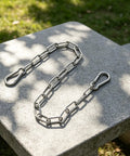 Stainless Steel Chain Gate Latch with Dual Carabiner Ends displayed on stone surface, showcasing durable links and carabiner ends.