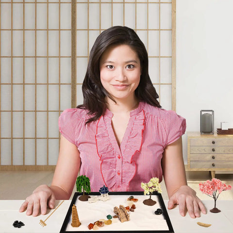 Mini Zen Garden Kit With White Sand, 10 By 7 Inch Rectangular Tray And Meditation Accessories on a desk in front of a person