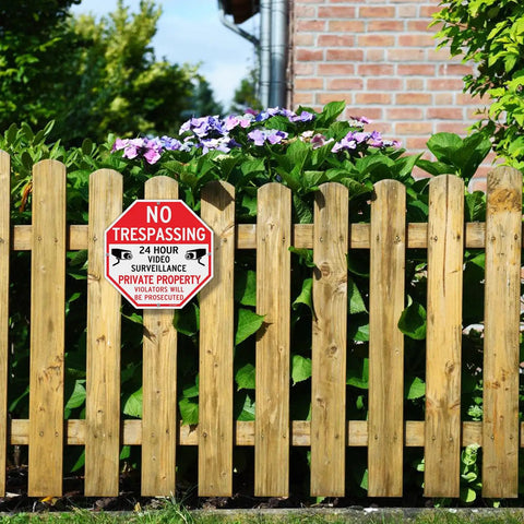 Keep Your Property Locked Tight With These Straight Up Heavy Duty No Trespassing Signs And Video Surveillance Notices Set Of Four Reflective 10 Inch Aluminum Plates With Pre Drilled Holes For No Sweat Fence Mounting. No Trespassing sign on wooden fence with flowers.