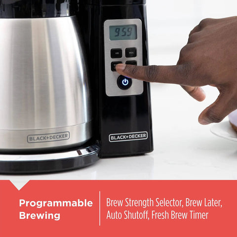 Person adjusting control panel on the 12 Cup Thermal Programmable Coffee Maker with Brew Strength and Vortex Technology, Black and Steel Finish.