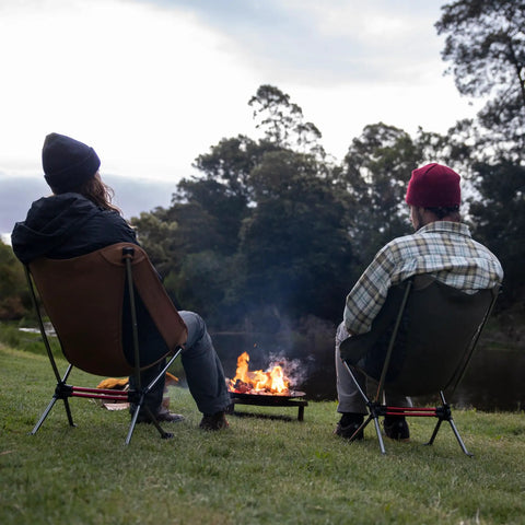 Two people sitting by a campfire on Ultralight Camping Chair For Backpacking With Anti Sink Feet Ultra Portable Folding Hiking Stool