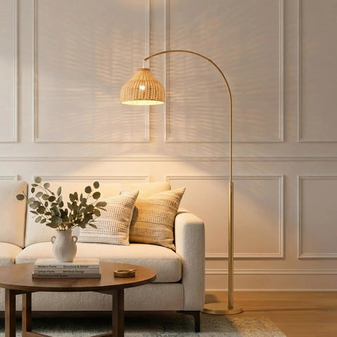 Lark Arc Floor Lamp With Hanging Wicker Shade Brass Tall Standing Light For Living Room And Office Perfect For Reading And Cozy Boho Chic Vibe Decor For Any Space next to a sofa.