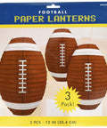 Football-shaped paper lantern pack showing three brown lanterns with white laces on packaging, 12 inches in size.