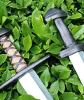 Two Pack 25 Inch Medieval Viking PU Foam Sword For Adults Costume Weapon Safe Soft Foam Larp Prop over green foliage.
