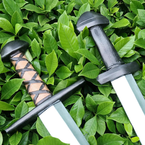 Two Pack 25 Inch Medieval Viking PU Foam Sword For Adults Costume Weapon Safe Soft Foam Larp Prop over green foliage.