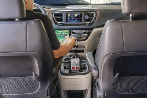 User charging a tablet with Badass Heavy Duty 500 Watt Power Inverter With Dual Usb Ports Vehicle Battery Clamps And 12V Dc Plug.