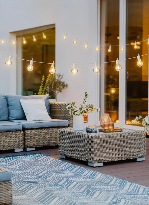 29 Feet LED Outdoor String Lights With Shatterproof G40 Edison Bulbs illuminating a cozy backyard patio with wicker furniture.