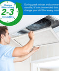Person installing a 12x24x1 Air Filter MERV 8 4 Pack Pleated Furnace And AC Filter Replacement in ceiling vent with installed airflow arrows.