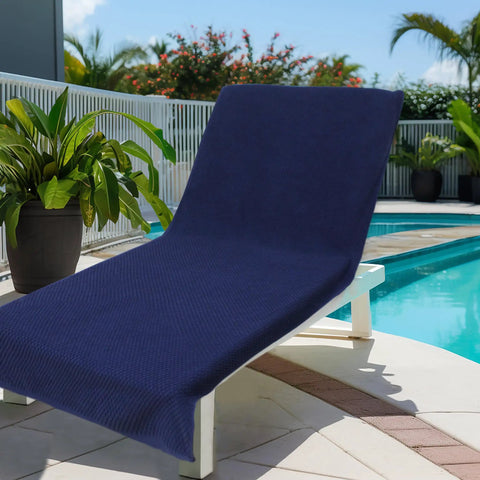 Two Pack Navy Blue Pool Lounge Chair Covers With Waffle Weave Cotton Terry Towels, Oversized 32 Inch Wide By 82 Inch Long Chaise Covers With A 7 Inch Pocket, Absorbent Beach Chair Towel Set by a poolside.