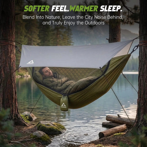 Man sleeping in 2 Person Camping Hammock With Mosquito Net And Built In Underquilt, Rain Fly Tarp, set up by a lake