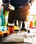 Heavy Duty Canvas Lewis Ice Crushing Bags 2 Pack Bartender Gear with cocktails and drinks on a wooden table.