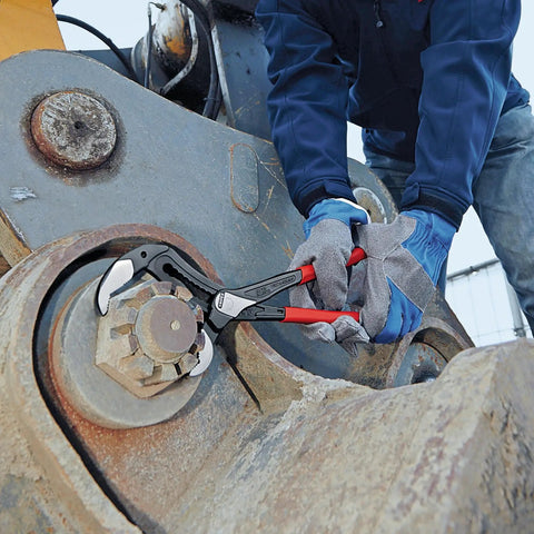 Alligator Water Pump Pliers XL 16 Inch Beefy Grip Self Locking For Pipes And Nuts in use on heavy machinery nut by gloved hands