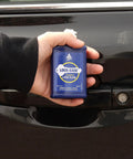 Person holding Lock-Ease lock fluid by car door for lubrication and maintenance, 3.5 oz bottle, used for locks and hinges.