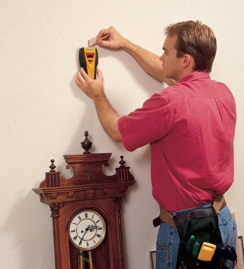 Person using Slick All In One Stud Finder Pins Wood Metal And Live Ac Wires Fast With A Bright Lcd Screen on wall.