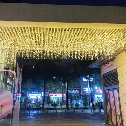 Warm White LED Icicle String Lights For Windows And Outdoor Spaces 16.4Ft 216 LEDs illuminating a covered walkway at night.