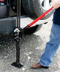 Person using Ratcheting Off Road Utility Farm Jack 33 Inch For Lifting Pulling Clamping And Winching 3 Ton 6000 Lb Capacity Red
