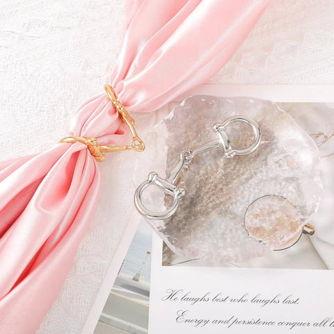 Two Piece Horse Bit Buckle Set Silk Scarf Buckle with gold and silver snaffle bit on pink silk background