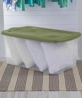 120 Qt Big Boy Storage Bin, Clear Plastic Tote With Green Lid, stacked with pillows, ideal for closet organization.