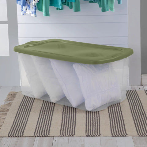 120 Qt Big Boy Storage Bin, Clear Plastic Tote With Green Lid, stacked with pillows, ideal for closet organization.