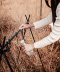 Person using Portable Aluminum Camping Storage Hook Rack With Six Hooks Foldable Tripod Design in outdoor setting