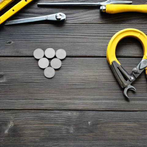10 Pack Round Stainless Steel Knockout Plugs For Junction Boxes And Electrical Panels arranged on a wooden surface with tools.