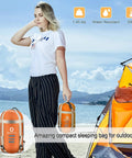 Person holding warm weather sleeping bag for outdoors portable waterproof and lightweight with compression sack, orange color.