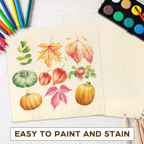 Two light basswood sheets with autumn leaf and pumpkin print; colored pencils and watercolor palette nearby