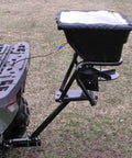 12V Grass Seed And Fertilizer Spreader With 80 Pound Capacity Hitch Mount Receiver on ATV, featuring heavy-duty 12V DC motor.
