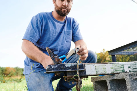 Man using 9.5 Inch Wire Crimping Tool for insulated and non-insulated terminals on outdoor wiring project with center cut pliers.
