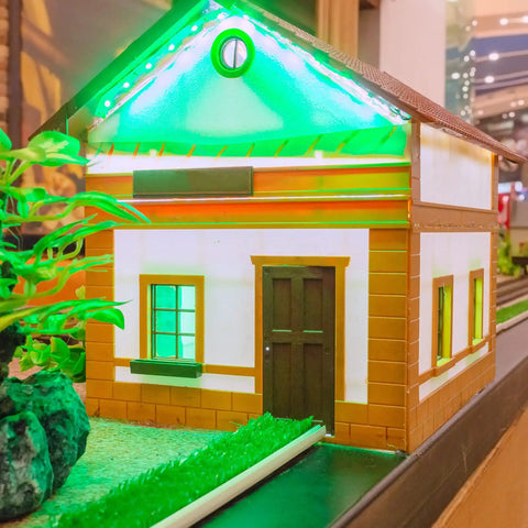 Miniature house decorated with 12V LED Lights Kit With 220 Pieces, green-lit roof, 3mm multicolor diodes for home decor.