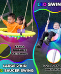 Children playing on Cedar Wood Swing Set With Nighttime LED Swings And Slide, 2 Person LED Saucer Swing, in backyard.