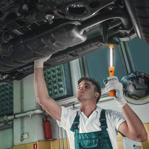 Mechanic using Lit 1000 Lumen LED Work Light With Rechargeable Design For Mechanics Dual Magnetic Bases And Hanging Hooks 4 Lighting Modes USB C Cable Perfect For Car Repair Home And Emergency Use under vehicle in garage.