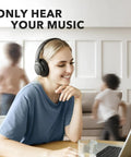 Woman using All Day Wireless Over Ear Headphones With Active Noise Canceling, 60 Hour Battery Life, Hi Res Audio indoors.