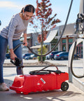 Woman refilling Flo N Go 14 Gallon Gas Caddy with 53 Liter Portable Fuel Tank, using built-in 10 foot hose at gas pump