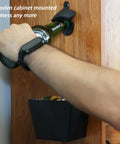 Heavy Wall Mounted Beer Bottle Opener With Slick Stainless Steel Cap Catcher Bucket Rustproof Black Cast Iron Finish Keeps The Man Cave Clean And Looking Fresh, mounted on wooden cabinet.