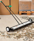 Built Different Heavy Duty 36 Inch Floor Magnetic Sweeper With Quick Release Lever For Warehouses And Shop Floors Picks Up Steel Scrap And Hardware Cleanup Rocks on workshop floor collecting screws and nails.