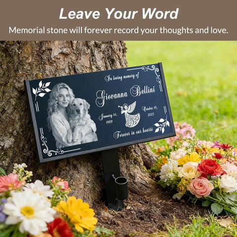 Natural Black Granite Headstone Grave Marker With Personalized Engraving resting against tree with flowers