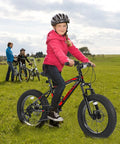 Child riding Fat Tire Kids Mountain Bike With 20X4 Inch Fat Tires Dual Disc Brakes Front Suspension 7 Speed All Terrain